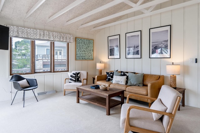 living room featuring beamed ceiling and carpet floors