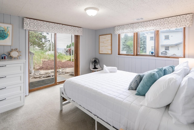 carpeted bedroom featuring access to exterior and a textured ceiling