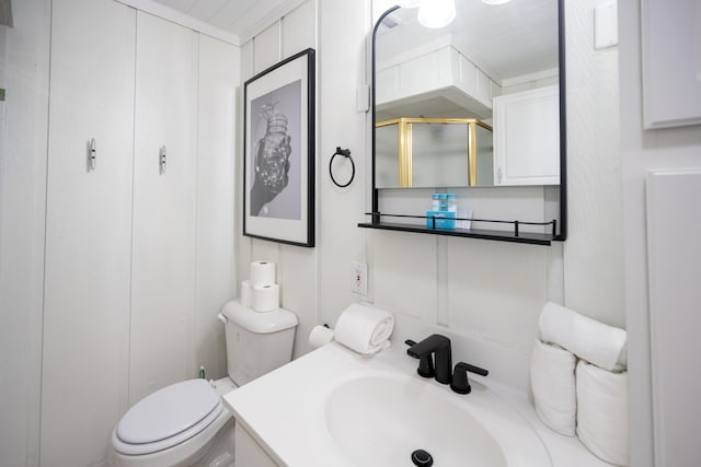 bathroom featuring an enclosed shower, vanity, and toilet