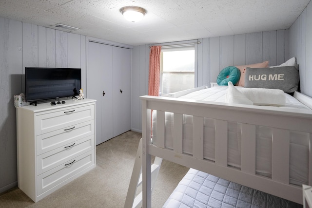 bedroom featuring light colored carpet and a closet