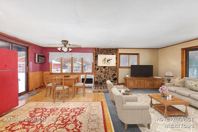 living room featuring heating unit, hardwood / wood-style flooring, an AC wall unit, and ceiling fan