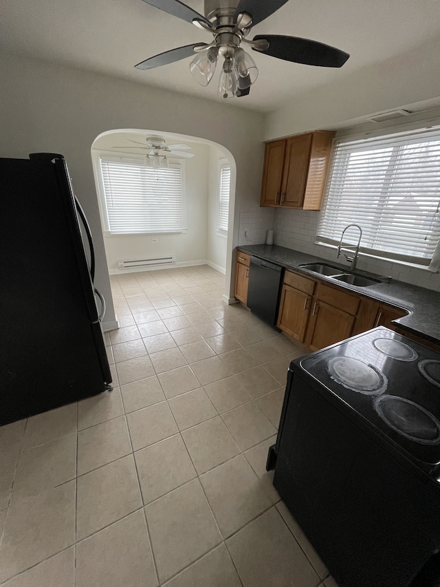 kitchen featuring sink, tasteful backsplash, black appliances, light tile patterned floors, and a baseboard heating unit