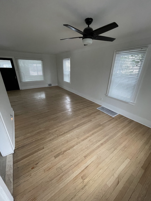 empty room with ceiling fan and light wood-type flooring