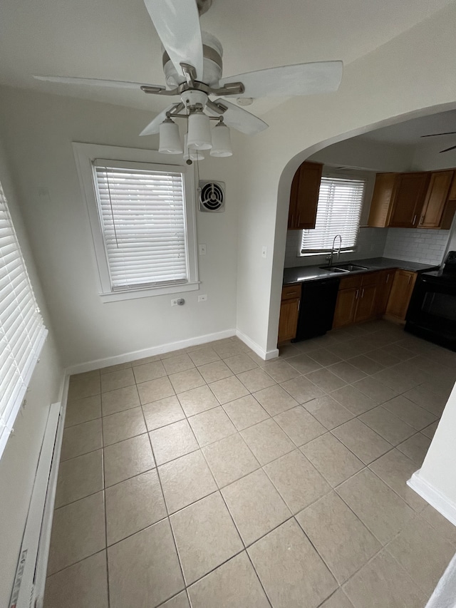 kitchen with sink, light tile patterned floors, a baseboard heating unit, black appliances, and decorative backsplash