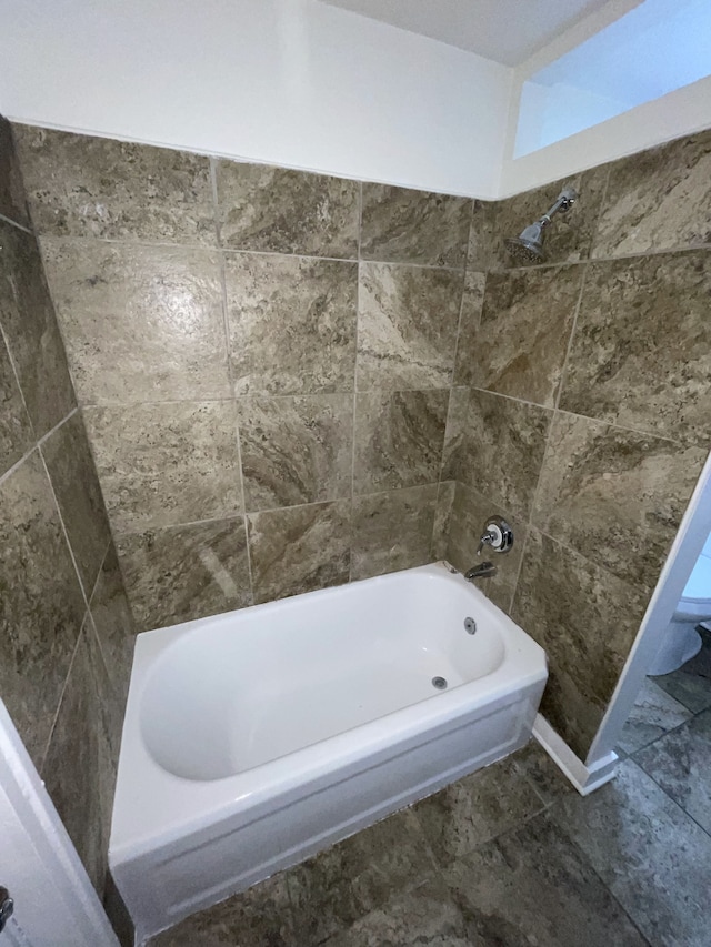 bathroom with tiled shower / bath and toilet