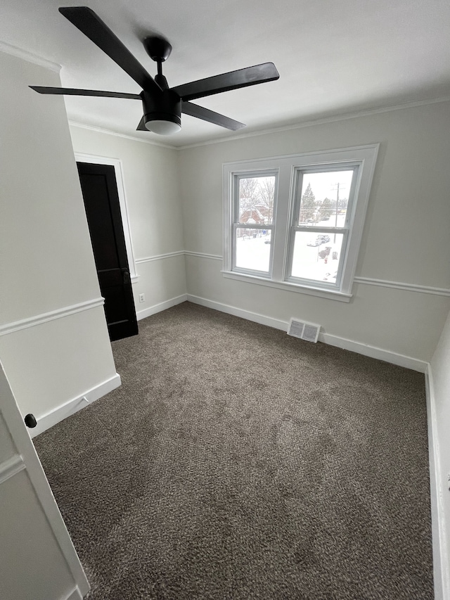 empty room featuring ornamental molding, carpet floors, and ceiling fan