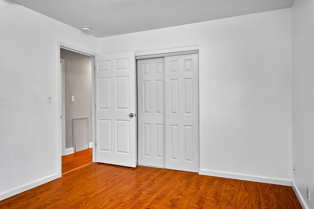 unfurnished bedroom featuring hardwood / wood-style flooring and a closet