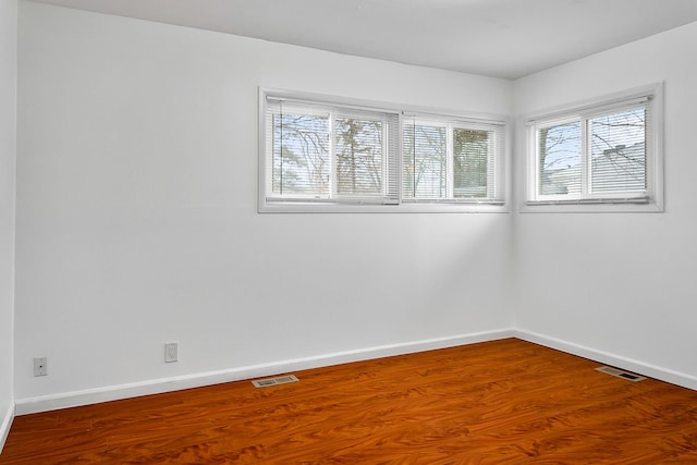 unfurnished room featuring wood-type flooring and a wealth of natural light