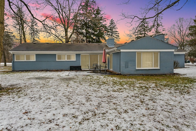 single story home with brick siding and a chimney