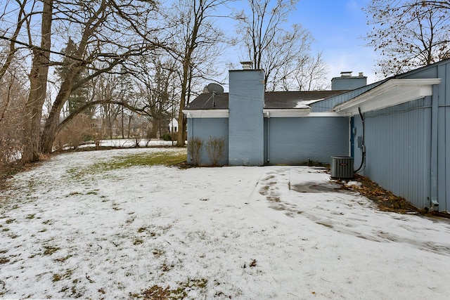 yard covered in snow with a garage and central air condition unit