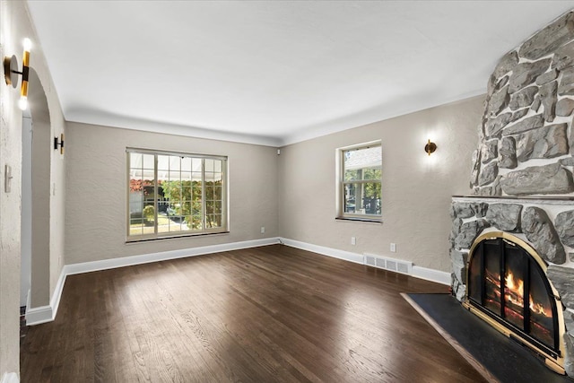 unfurnished living room with dark hardwood / wood-style flooring and a fireplace