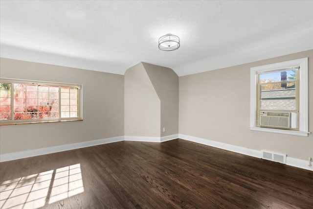 bonus room featuring cooling unit, vaulted ceiling, dark hardwood / wood-style floors, and a healthy amount of sunlight