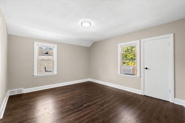 empty room with lofted ceiling, dark hardwood / wood-style floors, and cooling unit