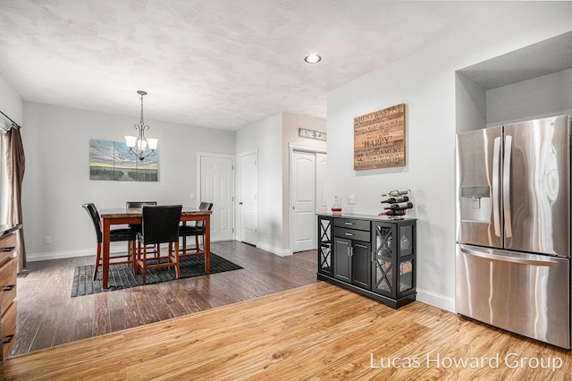 dining area featuring hardwood / wood-style flooring and a chandelier