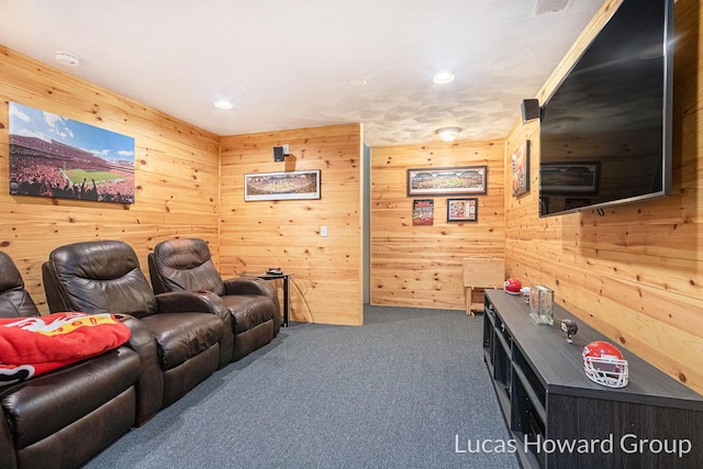 cinema room with dark carpet and wood walls