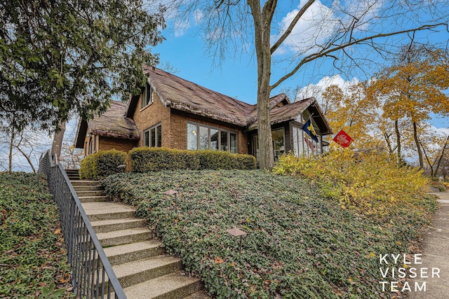 view of home's exterior with brick siding and stairway