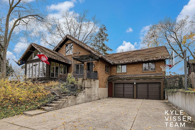 view of front facade with a garage, driveway, and brick siding