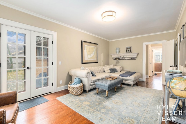 living area featuring ornamental molding, french doors, light wood-type flooring, and baseboards