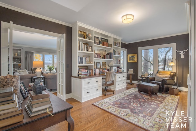 home office featuring crown molding, baseboards, and light wood-style floors