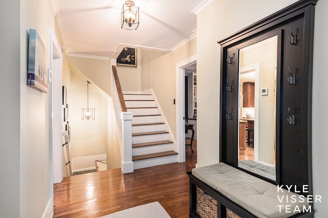 foyer entrance featuring dark wood-style floors, crown molding, and stairs