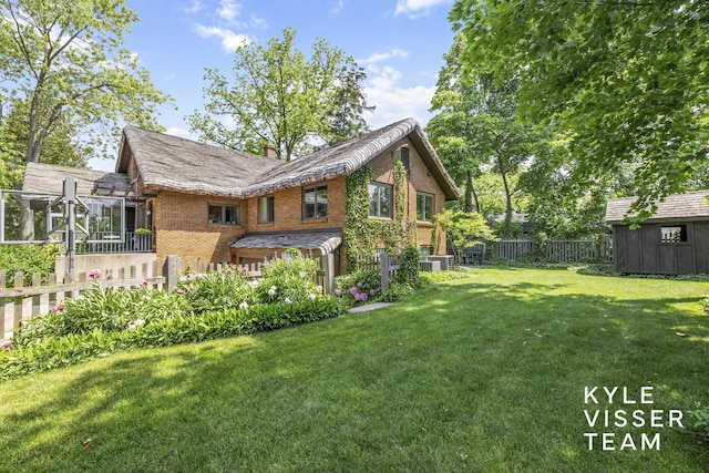2346 Lake Dr SE, East Grand Rapids, MI 49506 - back of house with brick siding, a storage shed, and a chimney