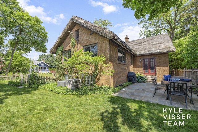 2346 Lake Dr SE, East Grand Rapids, MI 49506 - rear view of house with french doors, brick siding, a chimney, a patio, and entry steps
