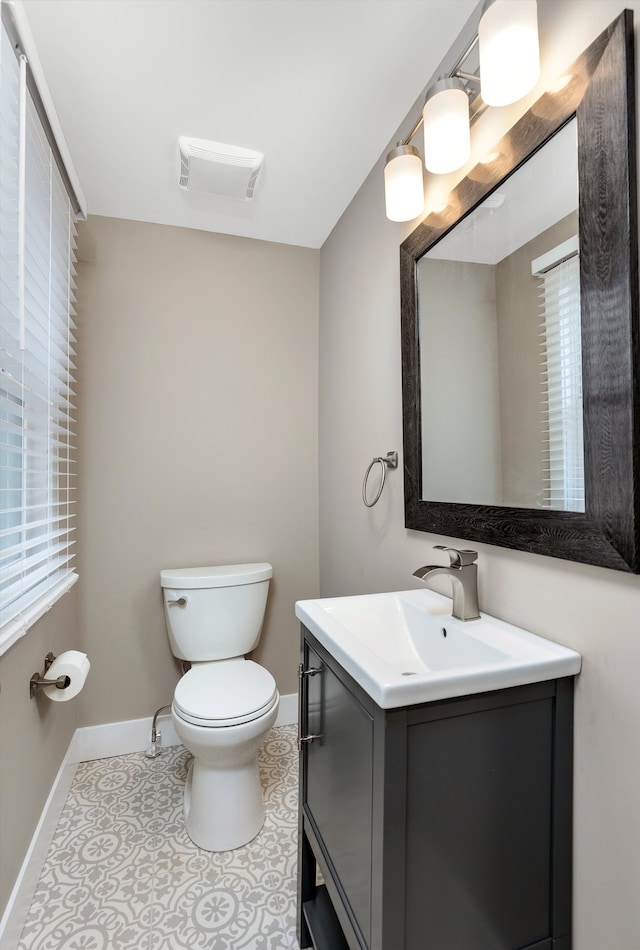 bathroom featuring vanity, a healthy amount of sunlight, tile patterned floors, and toilet