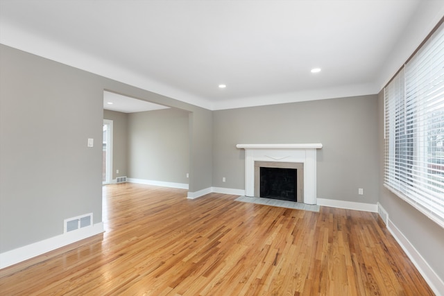 unfurnished living room with a fireplace and light hardwood / wood-style floors