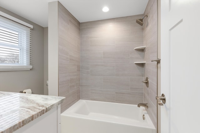 bathroom featuring vanity and tiled shower / bath