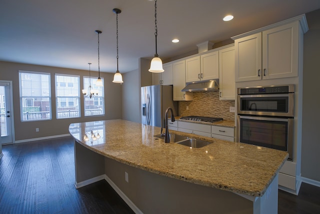 kitchen featuring white cabinetry, stainless steel appliances, sink, and a large island with sink