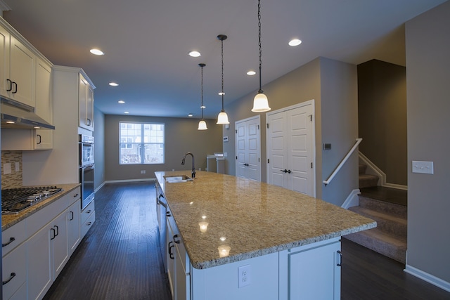 kitchen with sink, white cabinetry, decorative light fixtures, an island with sink, and stainless steel appliances