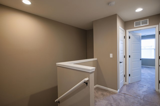 hall with light colored carpet