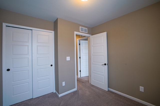 unfurnished bedroom featuring carpet and a closet