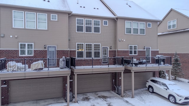 snow covered rear of property with a garage