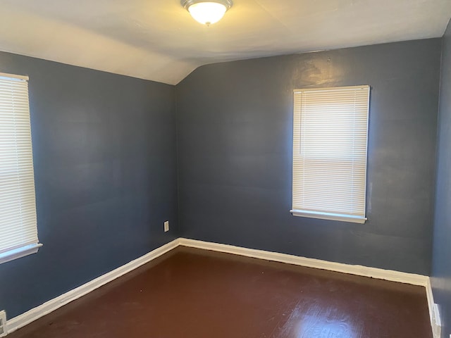 empty room with lofted ceiling and hardwood / wood-style floors