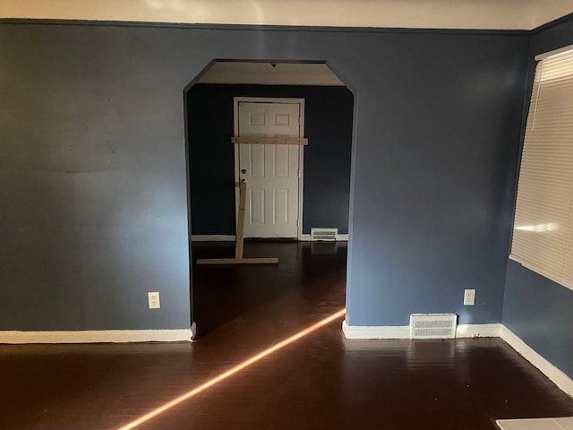 unfurnished room featuring dark wood-type flooring