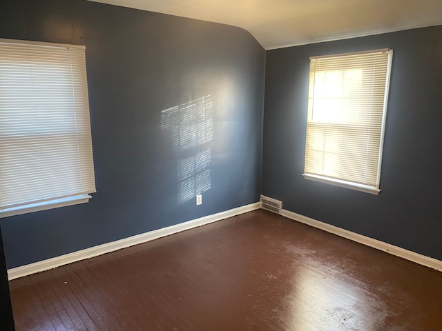 spare room with lofted ceiling and dark hardwood / wood-style floors