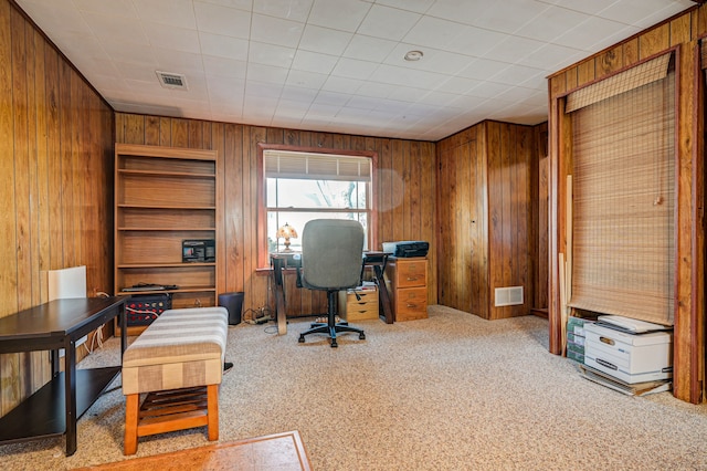 office area featuring light colored carpet and wooden walls