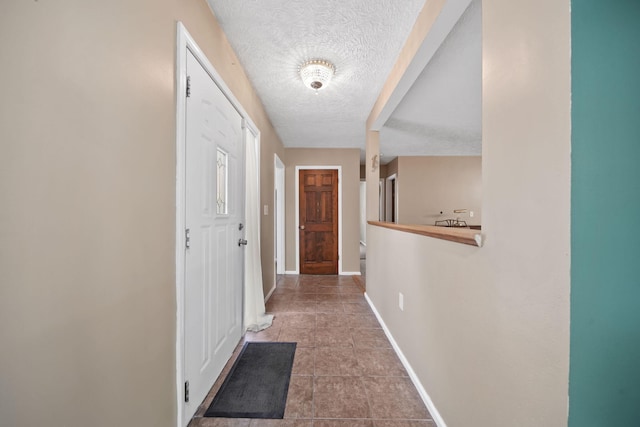 hallway with tile patterned flooring and a textured ceiling