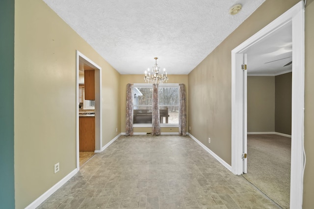 unfurnished dining area featuring a textured ceiling and a chandelier