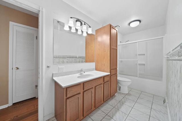 full bathroom featuring vanity, toilet, and combined bath / shower with glass door