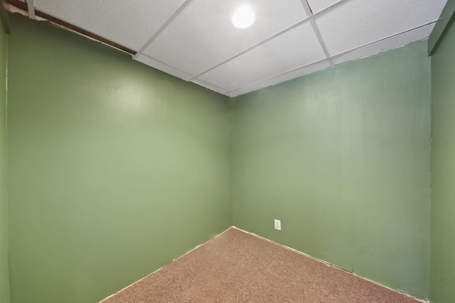 carpeted empty room with a drop ceiling