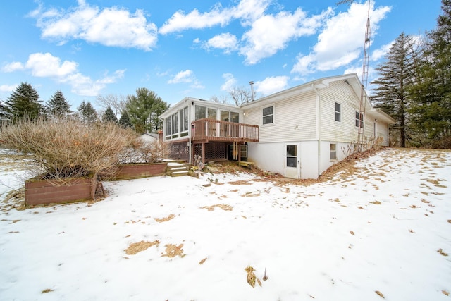 snow covered property featuring a sunroom