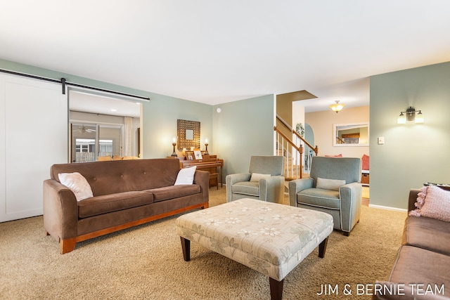 living room with a barn door and light colored carpet