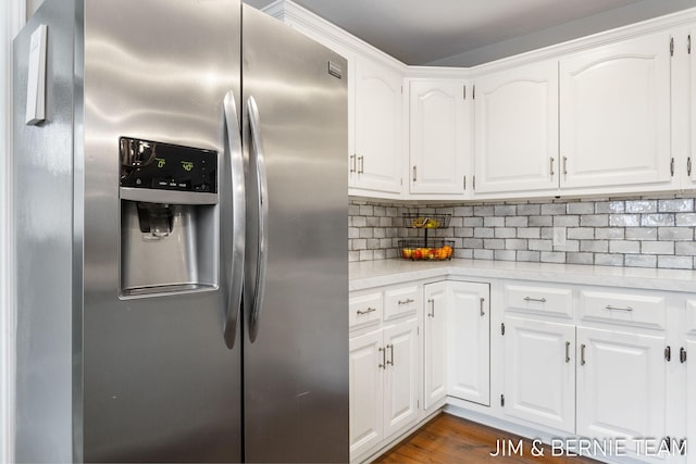 kitchen featuring stainless steel fridge with ice dispenser, decorative backsplash, dark hardwood / wood-style floors, and white cabinets