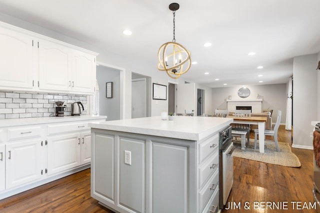 kitchen featuring white cabinetry, a kitchen island, dark wood-type flooring, and pendant lighting