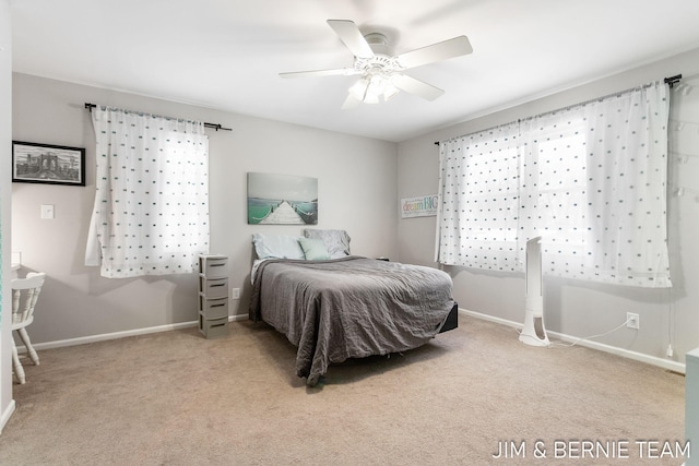 carpeted bedroom with ceiling fan and multiple windows