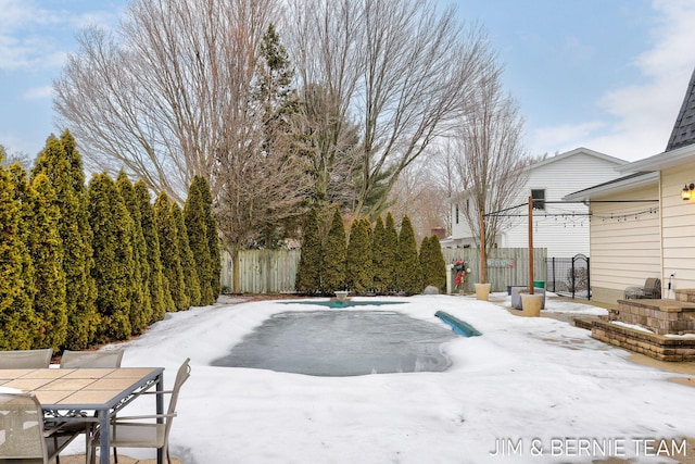 snowy yard with a covered pool and a patio