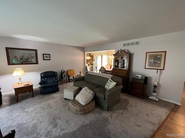 living room with visible vents, baseboards, and wood finished floors