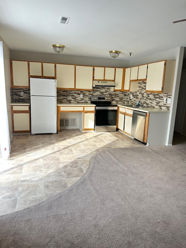 kitchen featuring tasteful backsplash, stainless steel appliances, ventilation hood, and light countertops